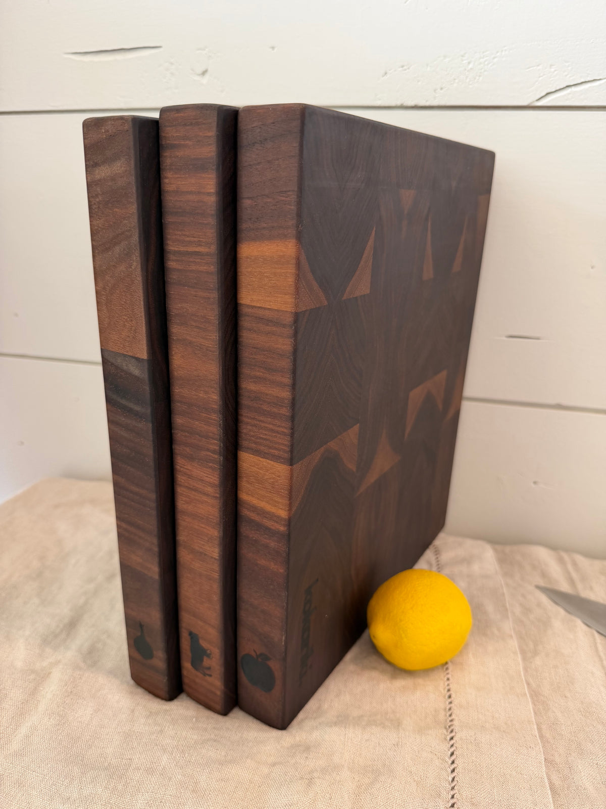 The Book of Boards in black walnut — three end-grain boards shelved like books